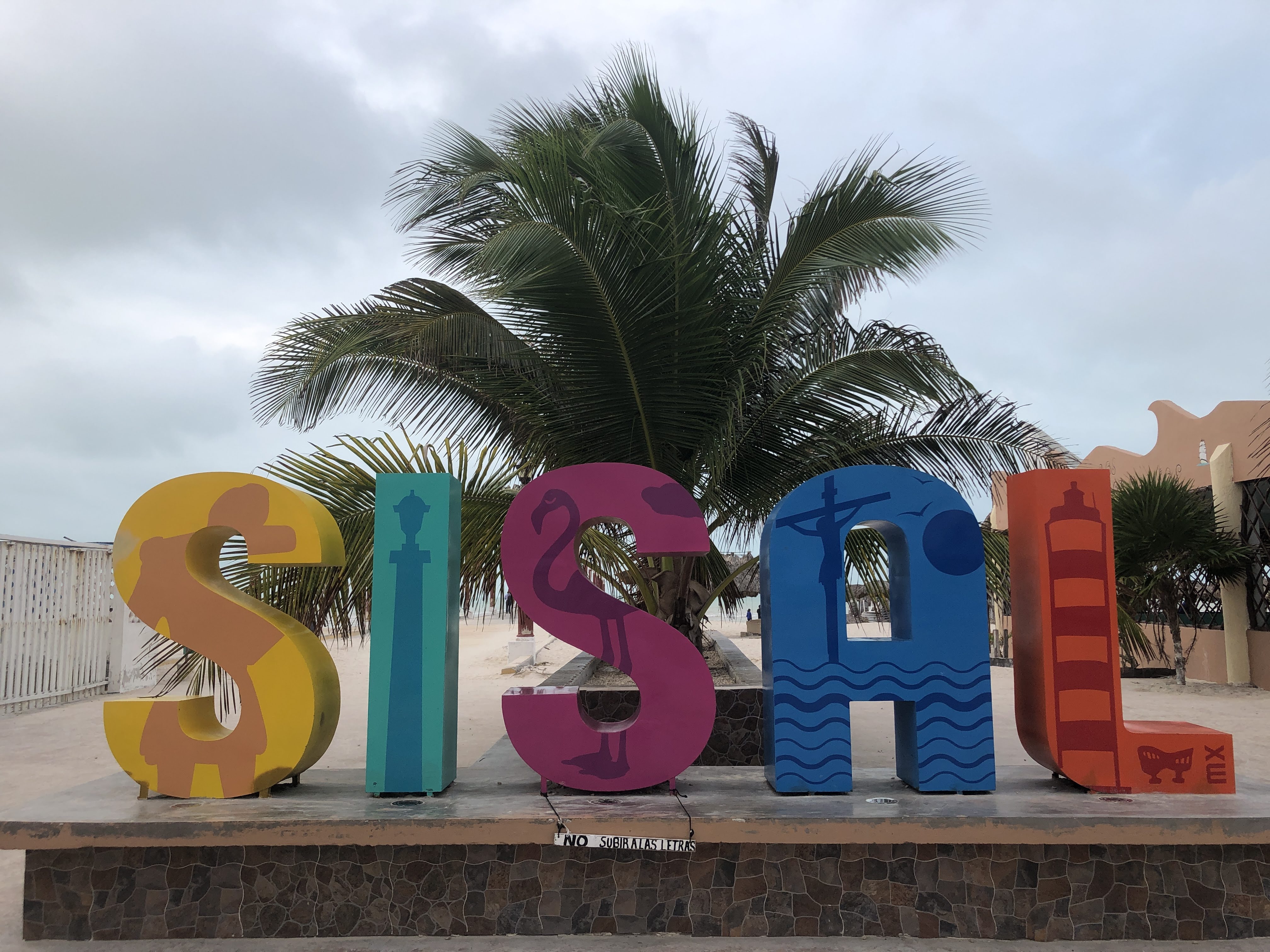 Letras de Sisal frente al paisaje costero